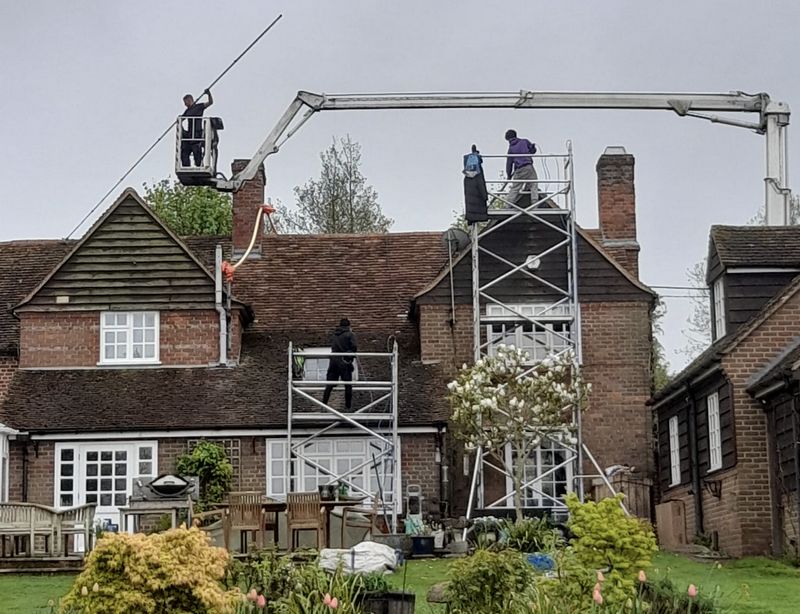 The Moss Cleaners using cherry picker and scaffolding to clean roof safely and professionally in Horsham, West Sussex